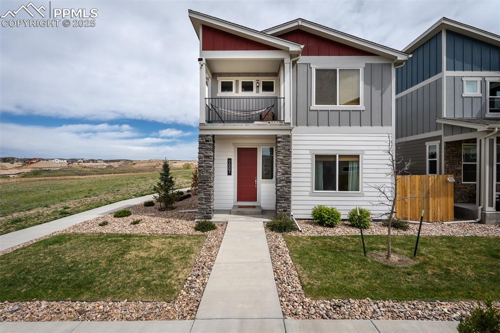Image 2 of 49: View of front of property featuring a balcony, board and batten siding, and