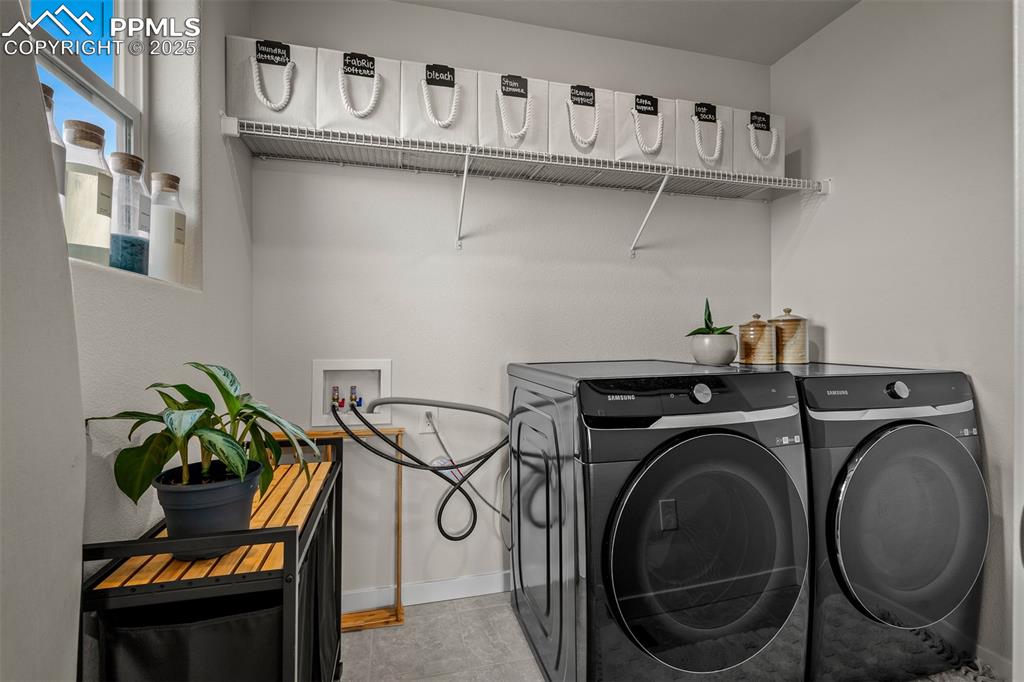 Image 38 of 49: Laundry area with separate washer and dryer and baseboards