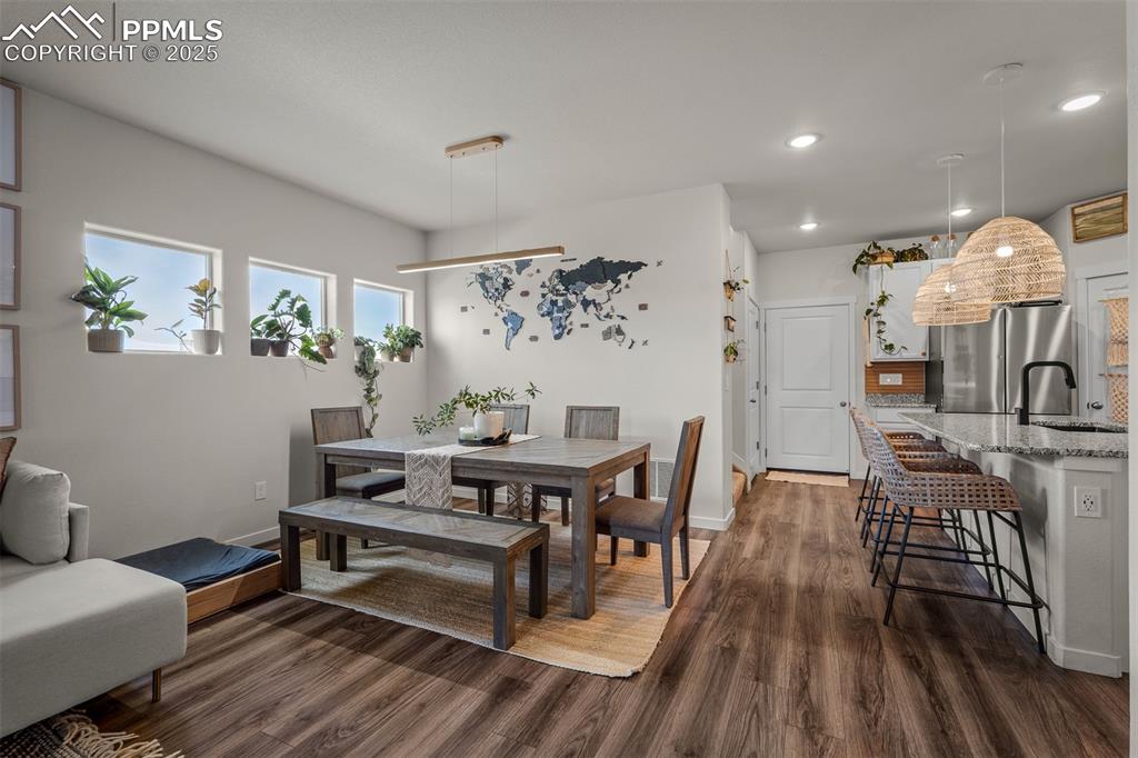 Image 8 of 49: Dining area with dark wood-style floors, recessed lighting, and baseboards