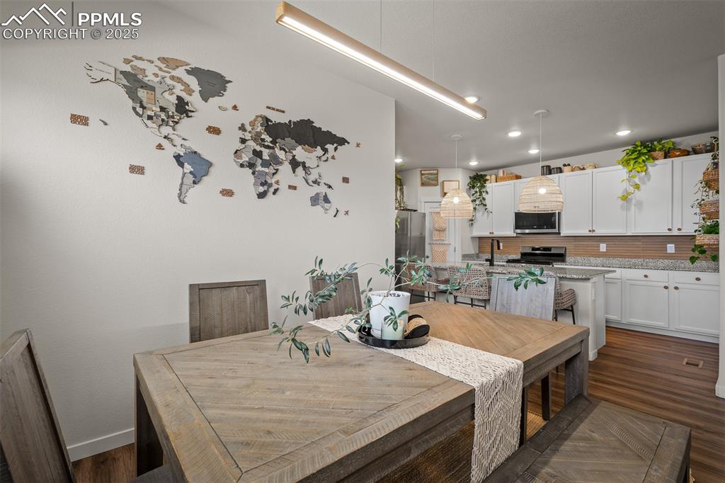 Image 9 of 49: Dining area with baseboards, dark wood finished floors, and recessed lighti