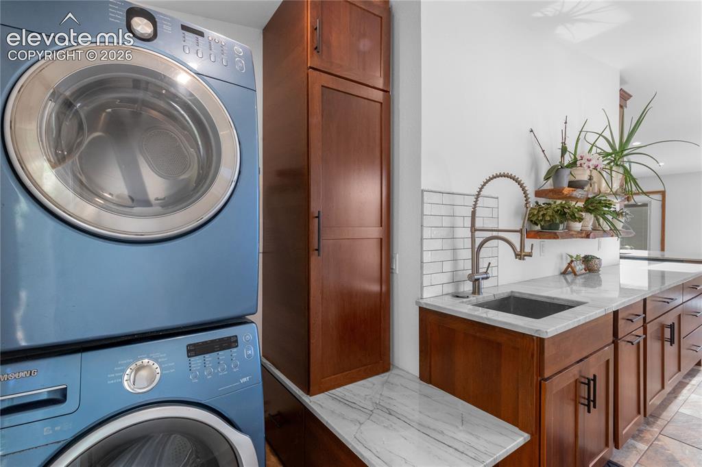 Image 24 of 50: Off from the Kitchen w/ Utility Sink, Utility Closet and Quartzite Througho