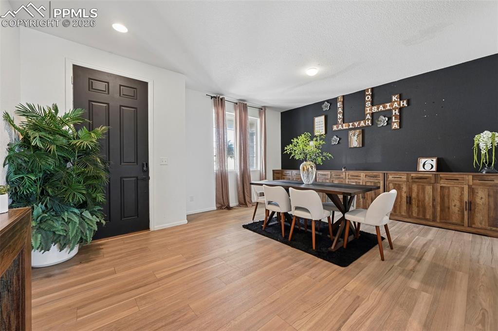 Image 11 of 43: Open-concept living area featuring light wood-finish flooring, recessed lig