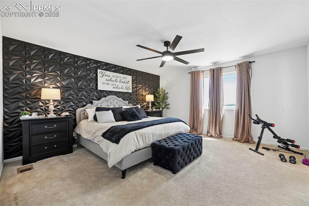 Image 12 of 43: Textured accent wall, neutral carpet flooring, and a contemporary ceiling f