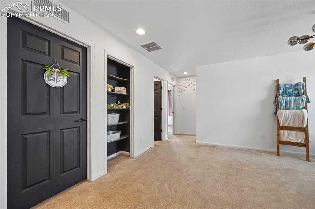 Image 14 of 43: Interior space featuring textured carpeting, white walls, and a built-in sh