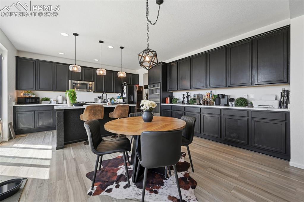 Image 2 of 43: Kitchen featuring extensive dark cabinetry, light-toned countertops, and wo
