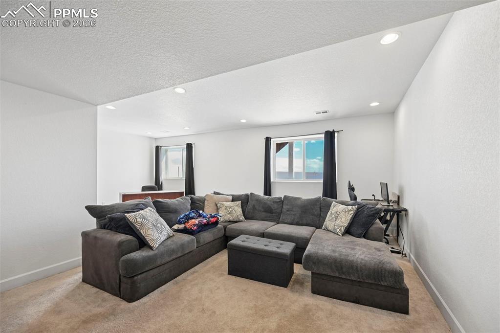 Image 21 of 43: Spacious room with plush carpet flooring and recessed lighting