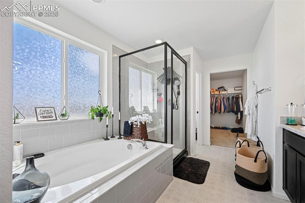 Image 22 of 43: Deep soaking tub with light gray subway tile surround