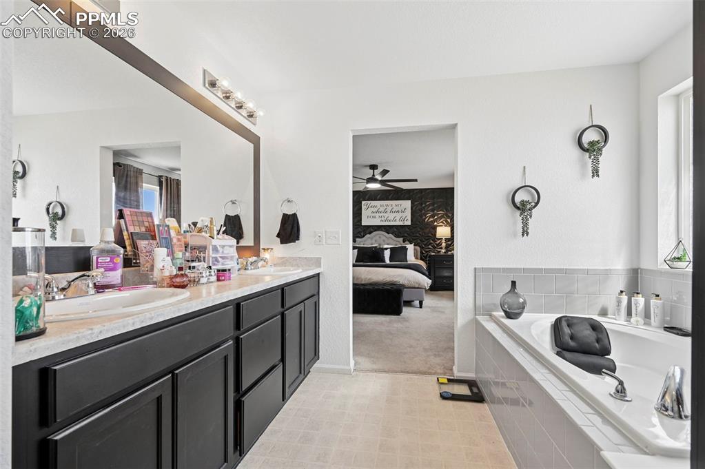 Image 23 of 43: Bathroom featuring a dual vanity with dark wood-finish cabinetry and a fram
