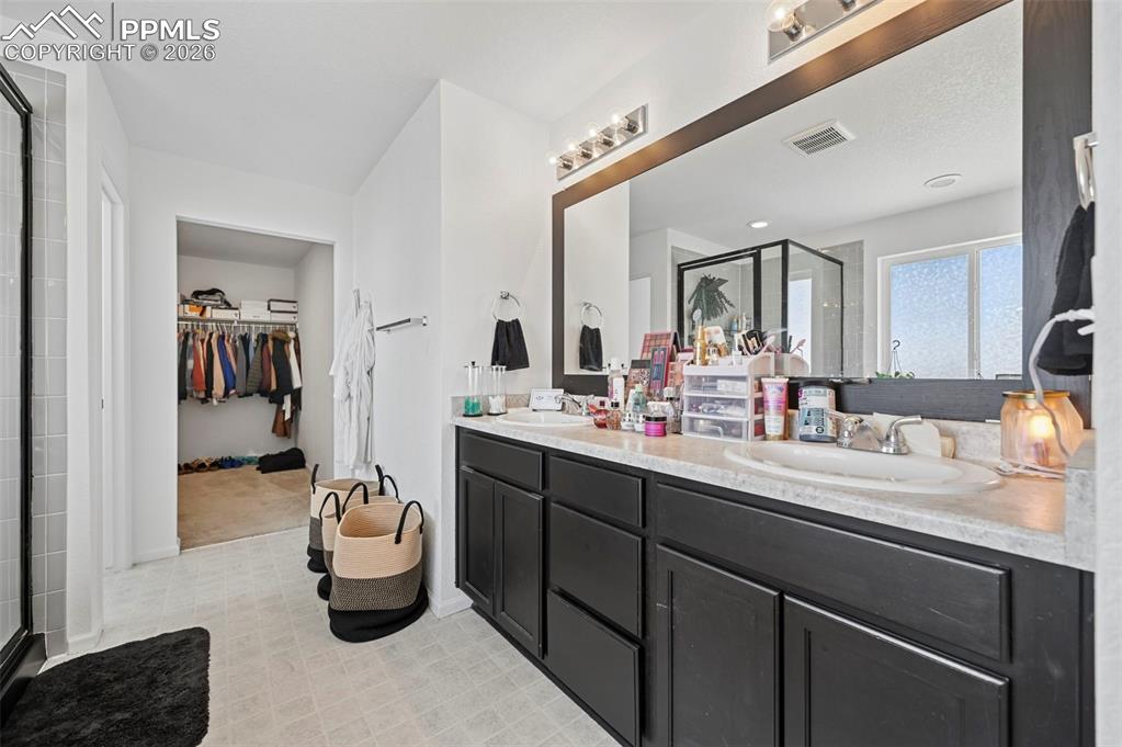 Image 24 of 43: Double vanity with dark wood-finish cabinetry and light countertops