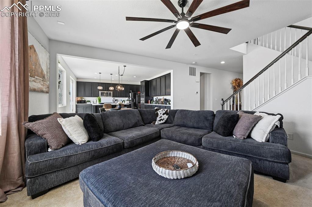 Image 3 of 43: Living area featuring a modern ceiling fan with wood-finish blades, light-t