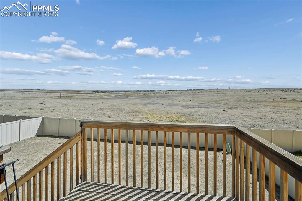 Image 38 of 43: Elevated wood deck with natural wood railing overlooking a private, fenced
