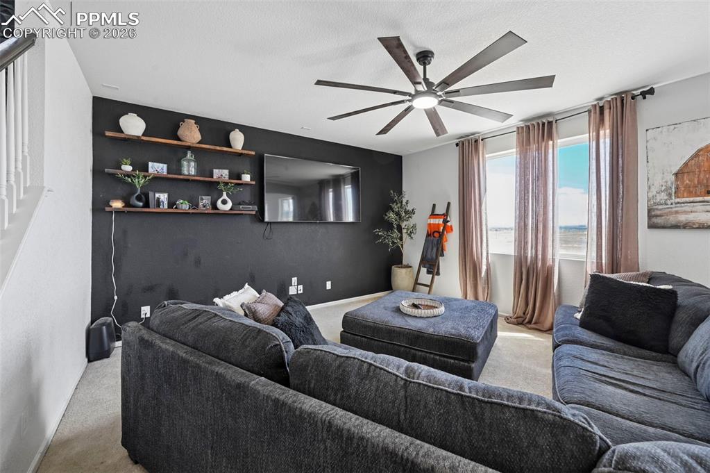 Image 4 of 43: Spacious living area featuring a dark accent wall with integrated shelving,