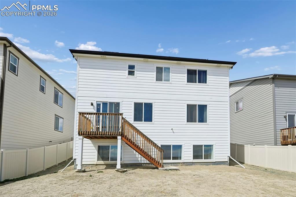 Image 41 of 43: Rear exterior featuring white horizontal siding and a wood-finish deck with