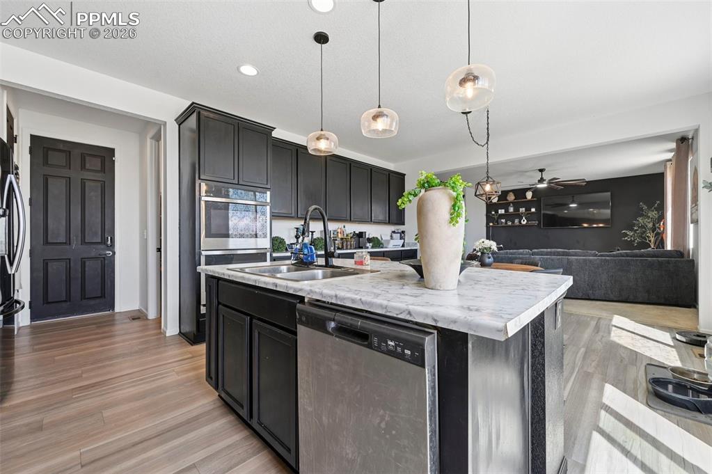Image 7 of 43: Modern kitchen featuring an island with a double basin sink, stainless stee