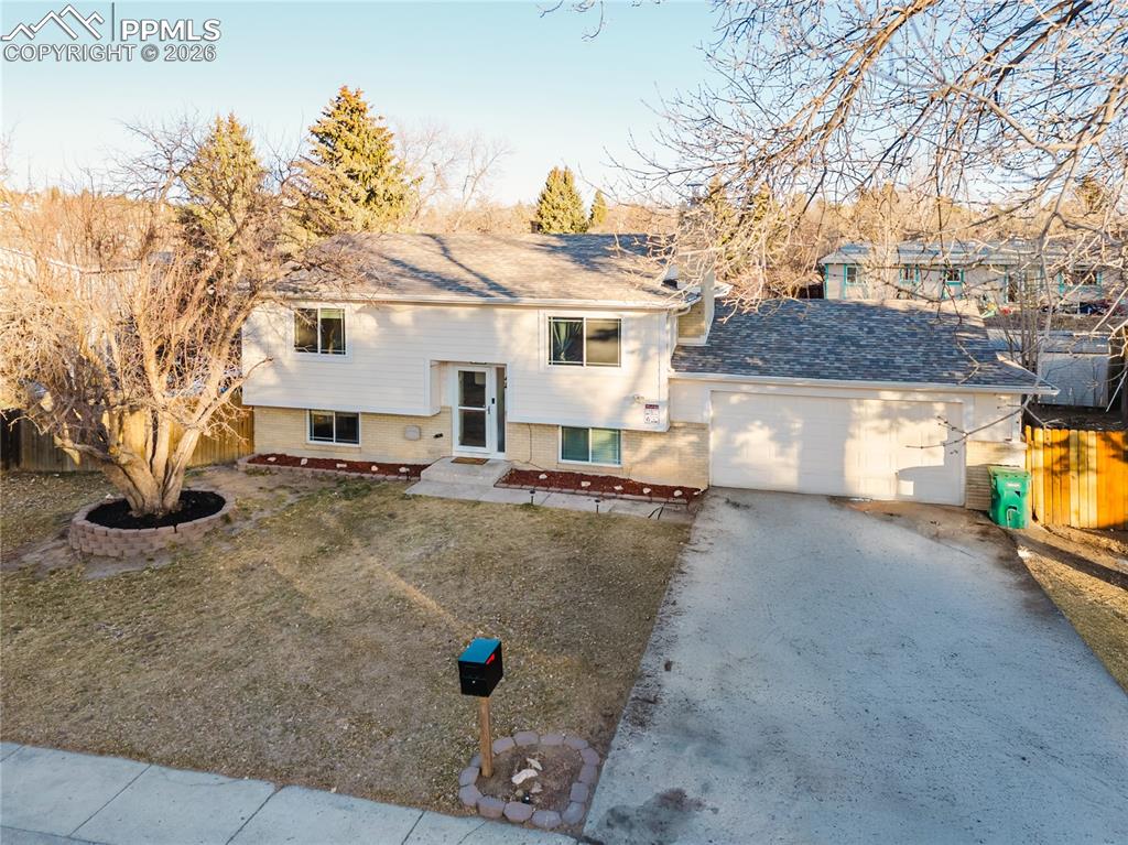 Image 1 of 20: Split foyer home featuring driveway, a garage, and brick siding