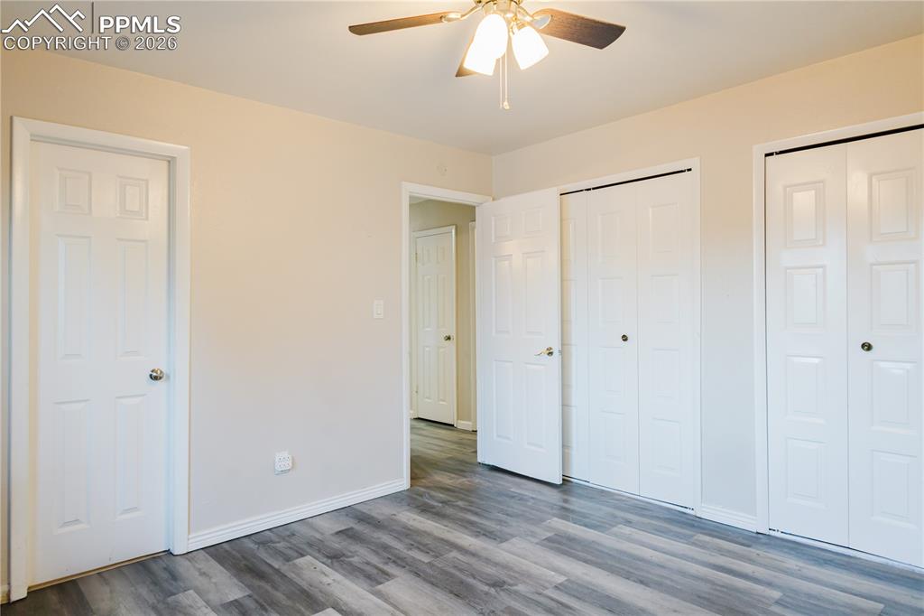 Image 14 of 20: Unfurnished bedroom with multiple closets, wood finished floors, and ceilin