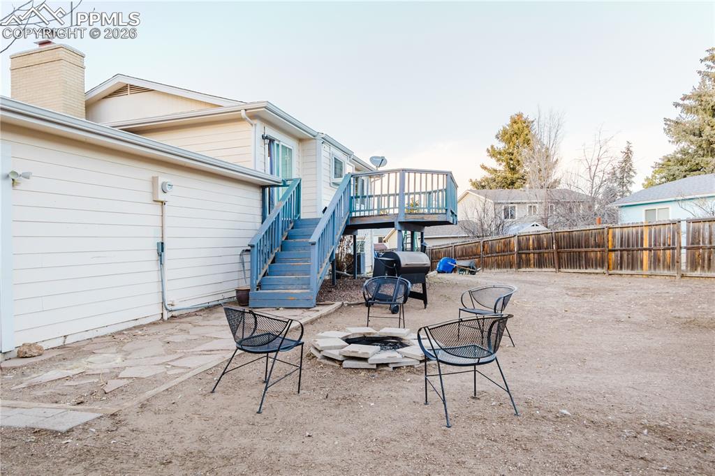 Image 17 of 20: Fenced backyard with a patio area, an outdoor fire pit, a wooden deck, and 