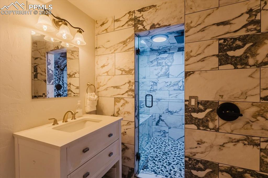 Image 22 of 45: Bathroom with white vanity, gold-finish faucet, and coordinating wall-mount