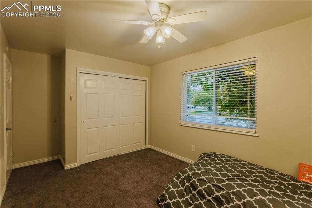 Image 29 of 45: Bedroom featuring neutral wall paint, a ceiling fan with light fixture, win