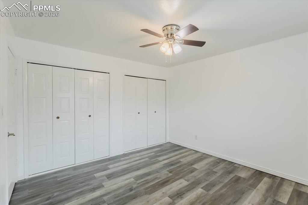 Image 31 of 45: Room featuring wood-finish flooring, a ceiling fan with light fixture, and