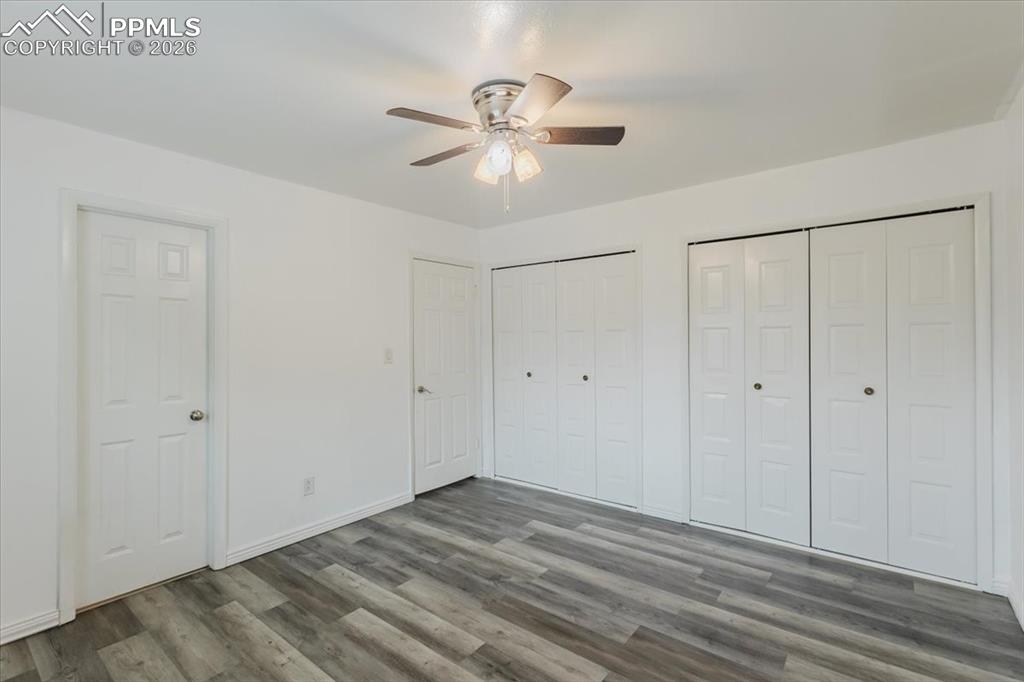 Image 33 of 45: Spacious room featuring wood-finish flooring, bright white walls, and a cei