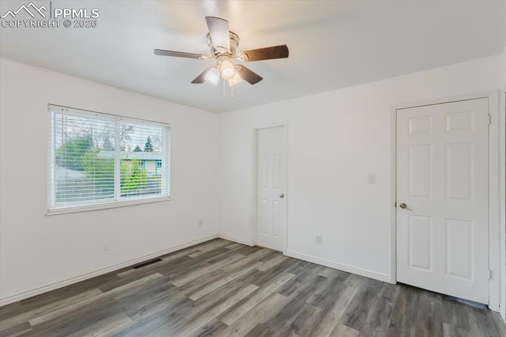 Image 34 of 45: Room featuring wood-finish flooring, a ceiling fan with integrated lighting