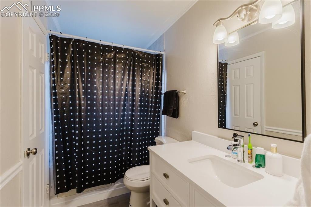 Image 35 of 45: Bathroom featuring a white vanity with integrated sink, chrome faucet, and