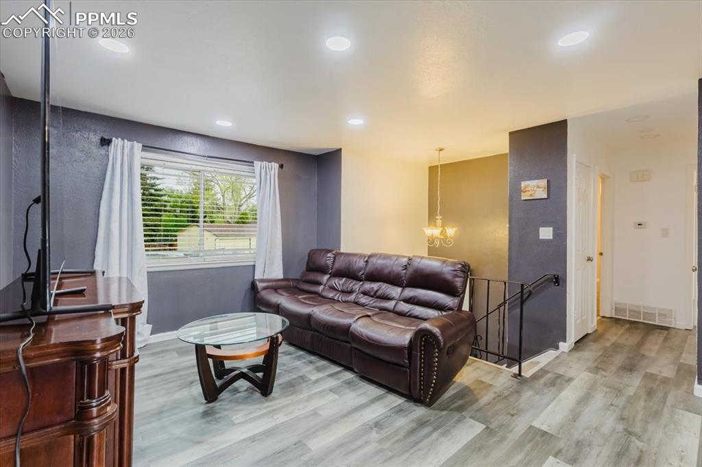 Image 38 of 45: Living area featuring wood-finish flooring, recessed lighting, and a window