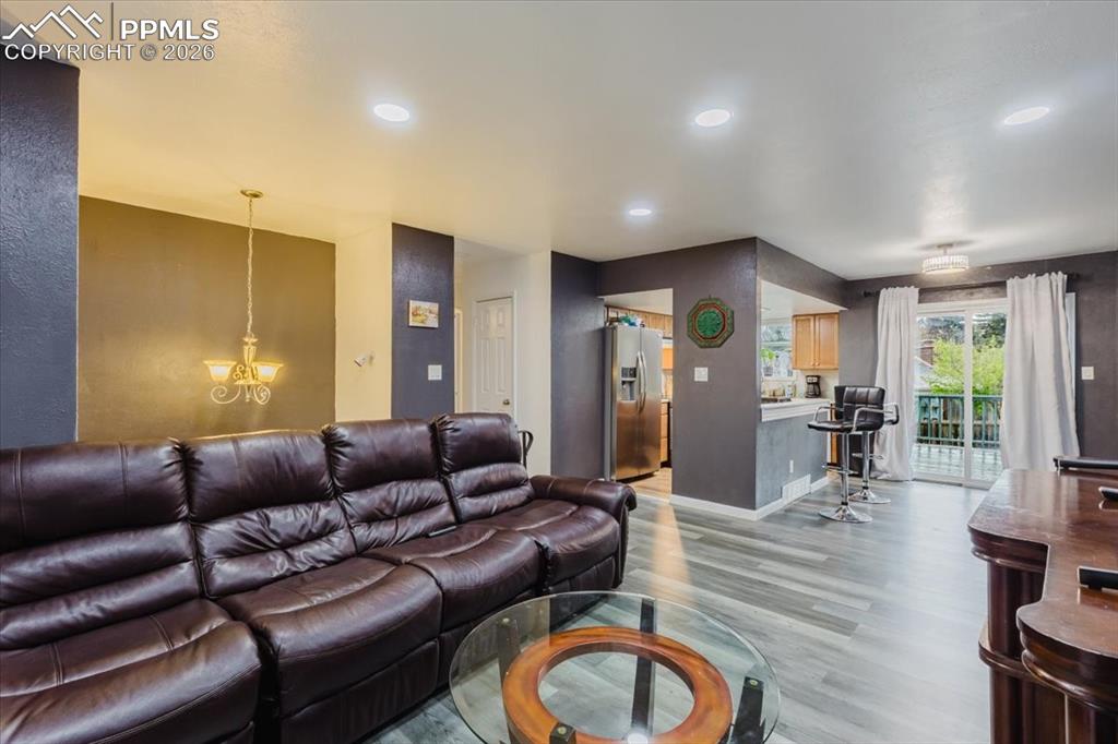 Image 39 of 45: Open-concept living space featuring wood-finish flooring, recessed lighting