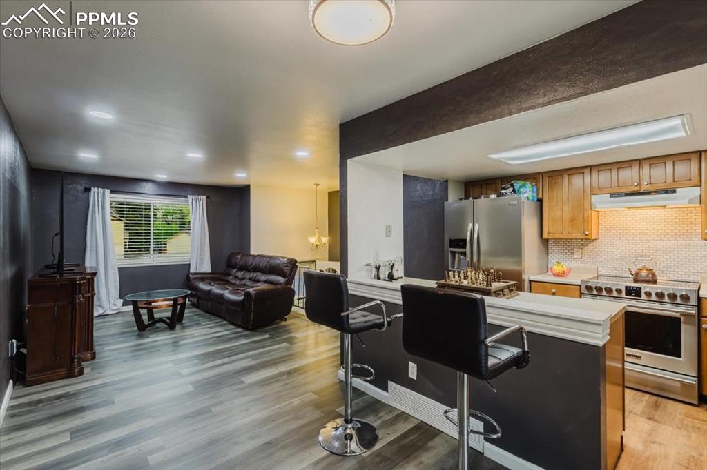 Image 40 of 45: Open-concept kitchen and living area featuring wood-finish flooring, recess