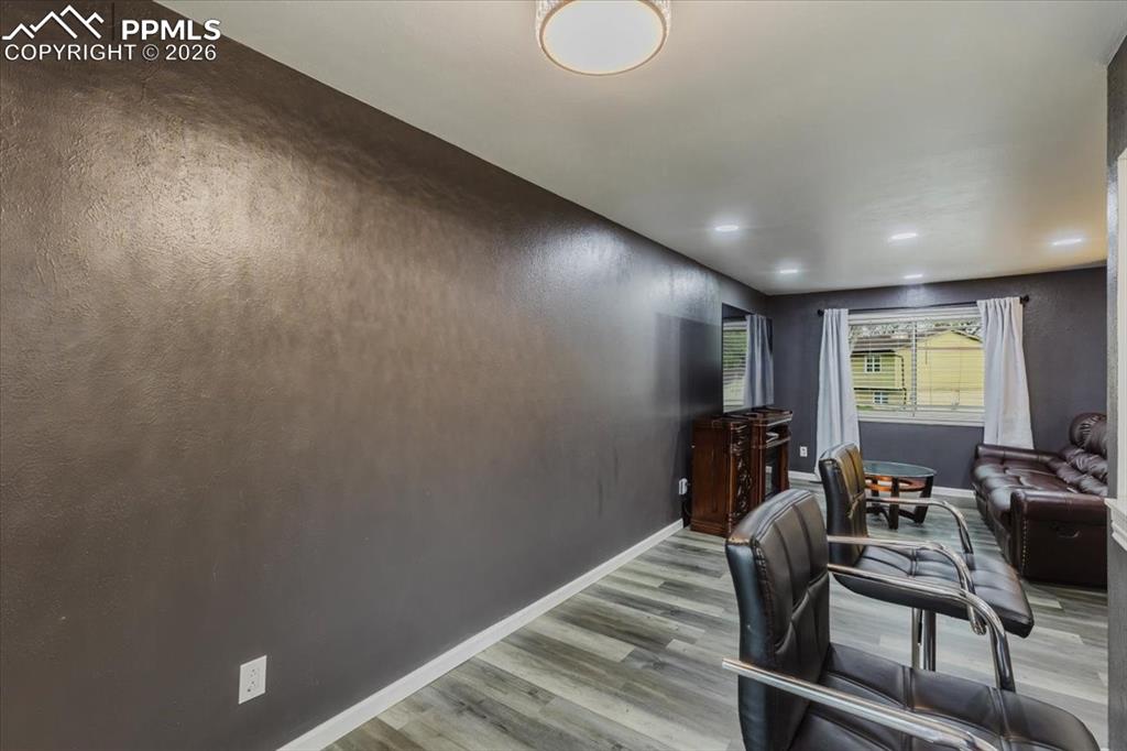 Image 41 of 45: Spacious interior featuring a textured accent wall, light wood-finish floor