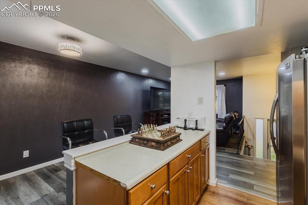 Image 44 of 45: Kitchen island with wood cabinetry and light-toned countertop