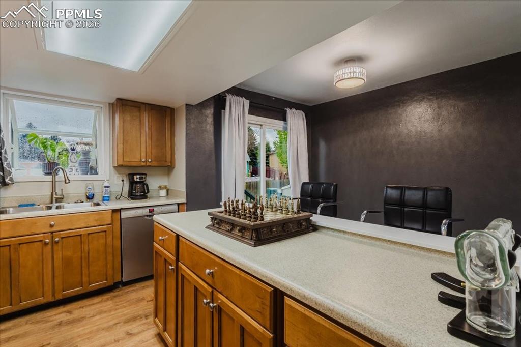 Image 45 of 45: Kitchen featuring wood-finish flooring, a double basin sink with a goosenec