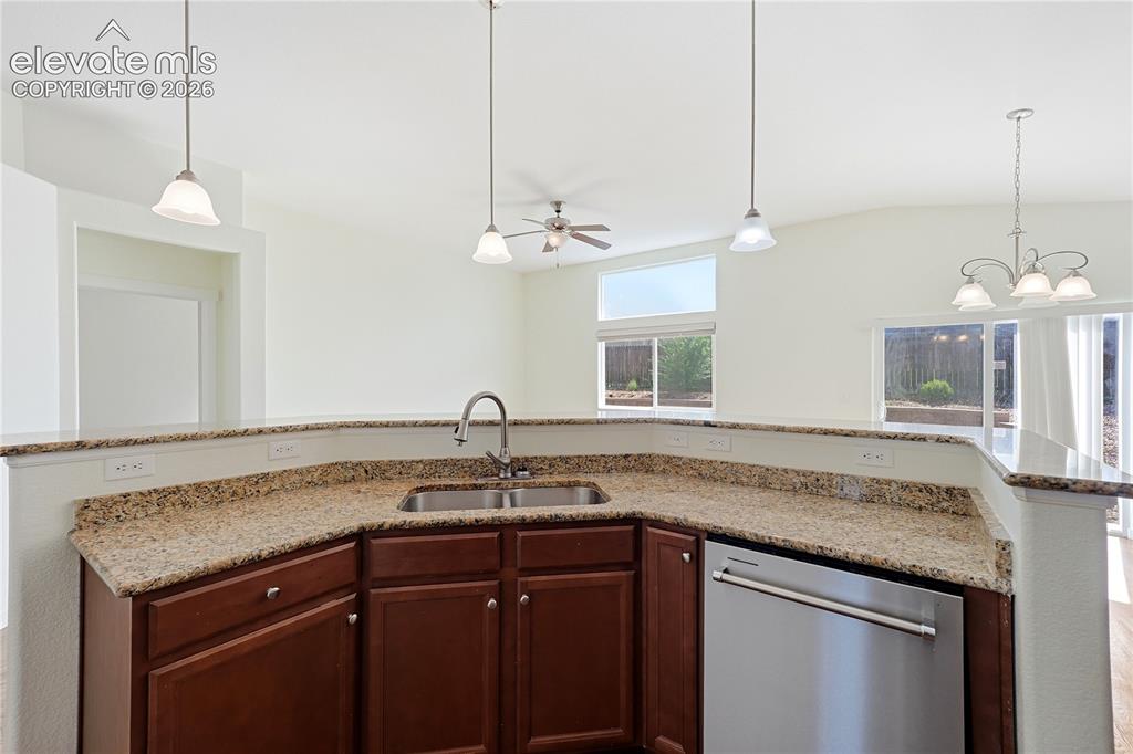 Image 10 of 46: Open-concept living area with dark wood-finish flooring, vaulted ceilings, 