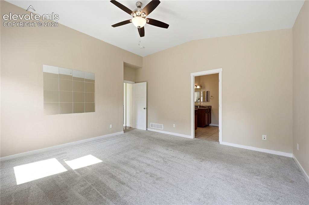 Image 15 of 46: Vaulted ceiling with a ceiling fan, neutral wall color, and carpeted floori