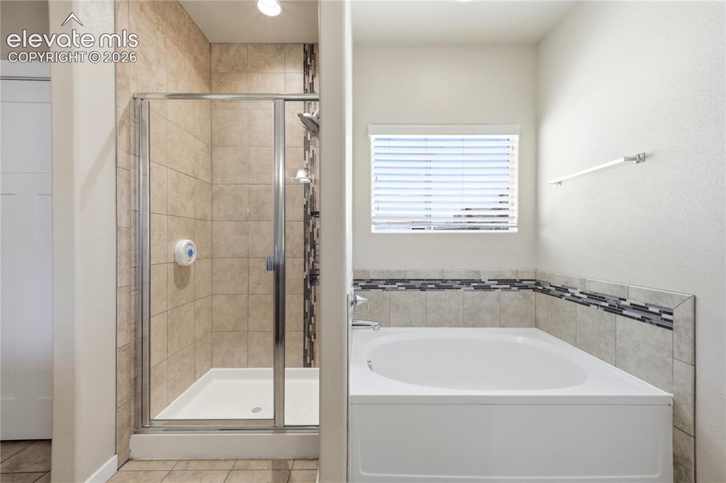 Image 19 of 46: Walk-in shower with clear glass enclosure and tile surround