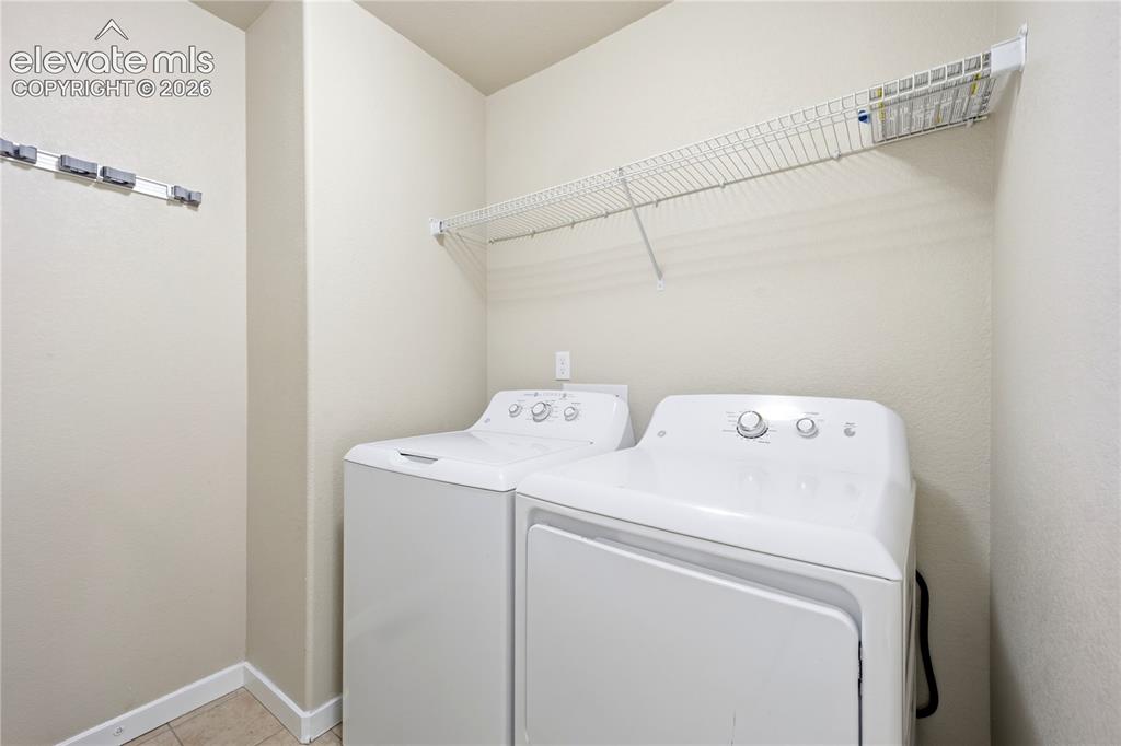 Image 21 of 46: Wire shelving, tile flooring, and wall-mounted utility hooks