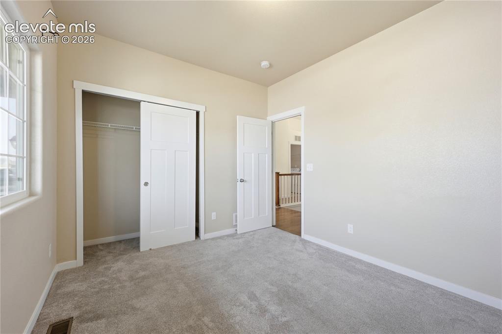 Image 23 of 46: Soft gray carpeting, neutral wall finishes, white trim, sliding closet door