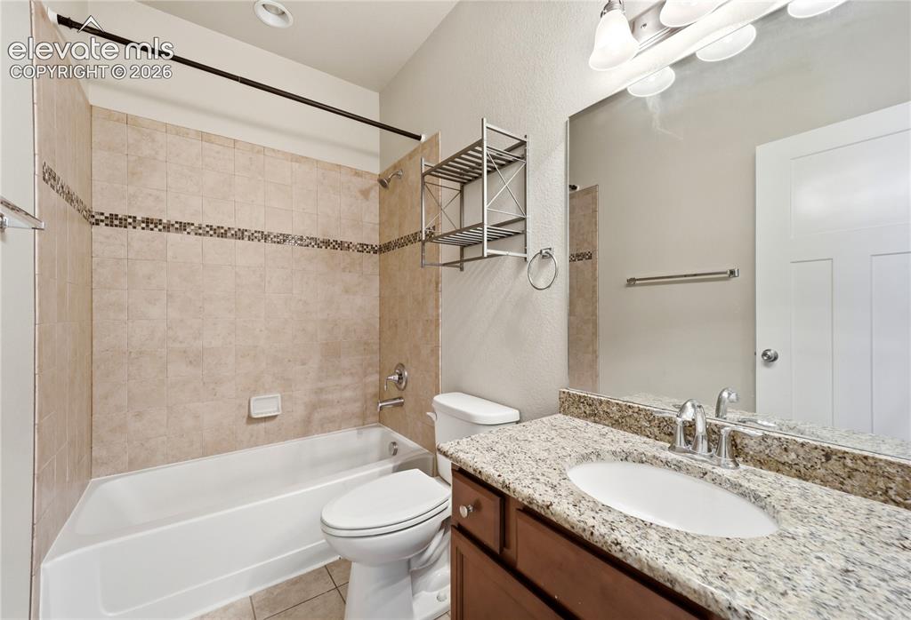 Image 24 of 46: Tub-shower combination with tiled surround and decorative accent band