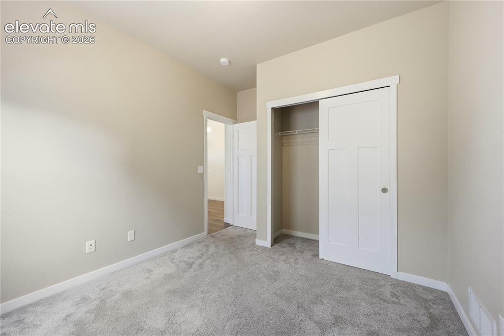 Image 26 of 46: Plush gray carpeting, neutral wall paint, white trim, and a white sliding c