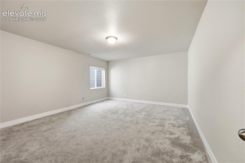 Image 35 of 46: Carpeted room with a single window, white trim, and a flush-mount ceiling l