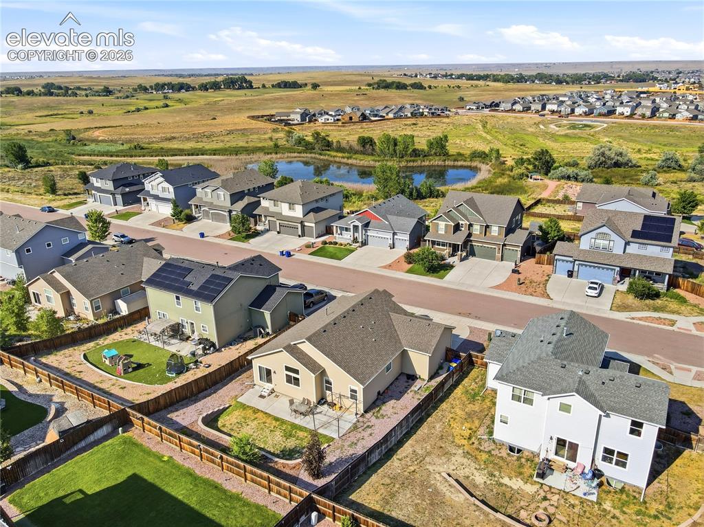 Image 42 of 46: Neighborhood setting with residential properties, paved streets, and a pond