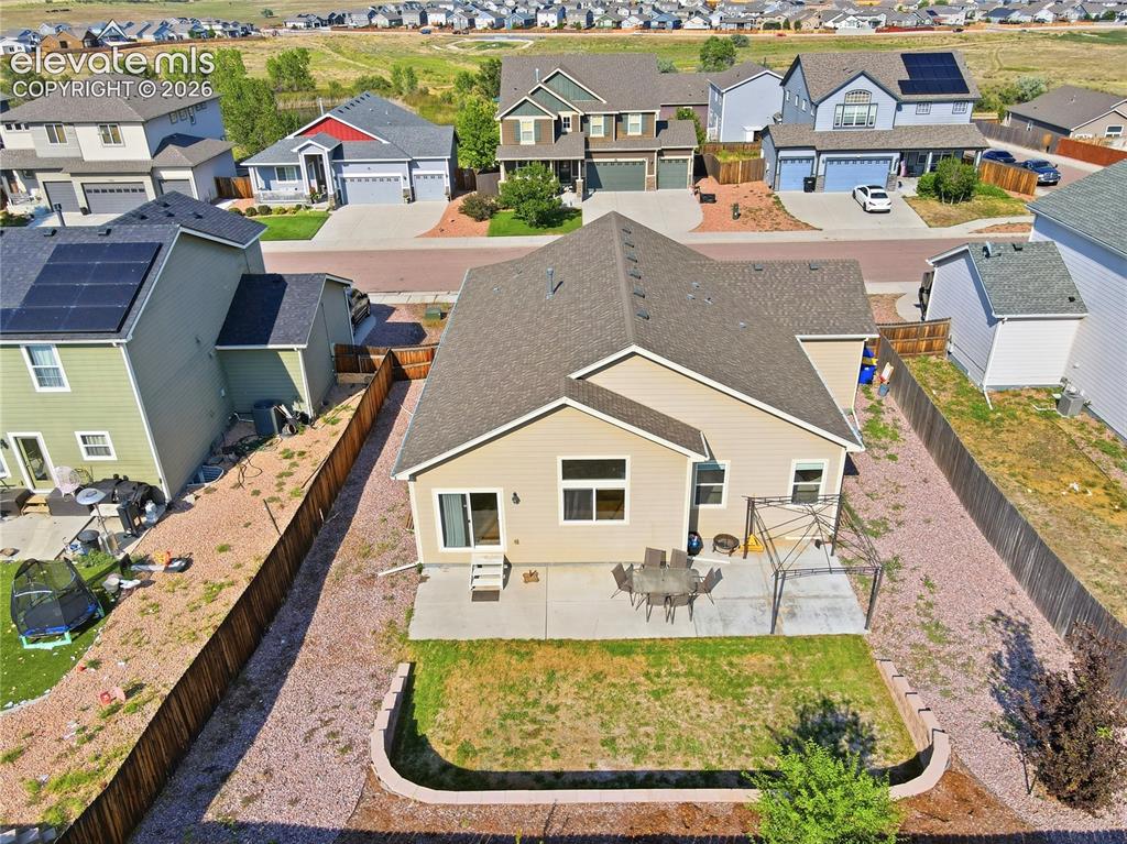 Image 43 of 46: Rear exterior with neutral siding, a concrete patio, and a grassy area