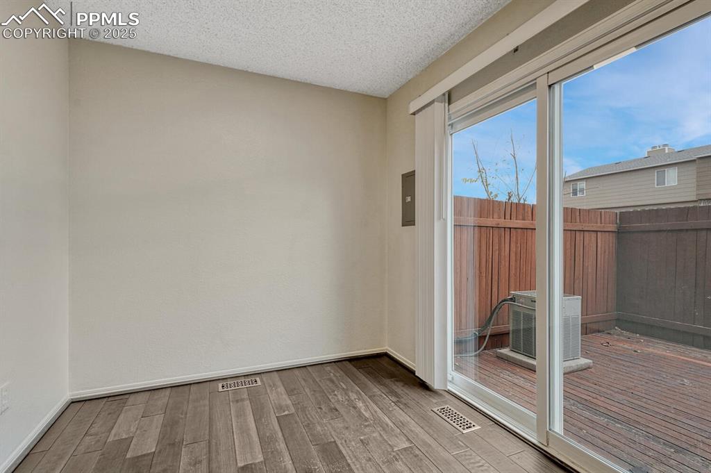 Image 17 of 32: Unfurnished room with wood finished floors and a textured ceiling