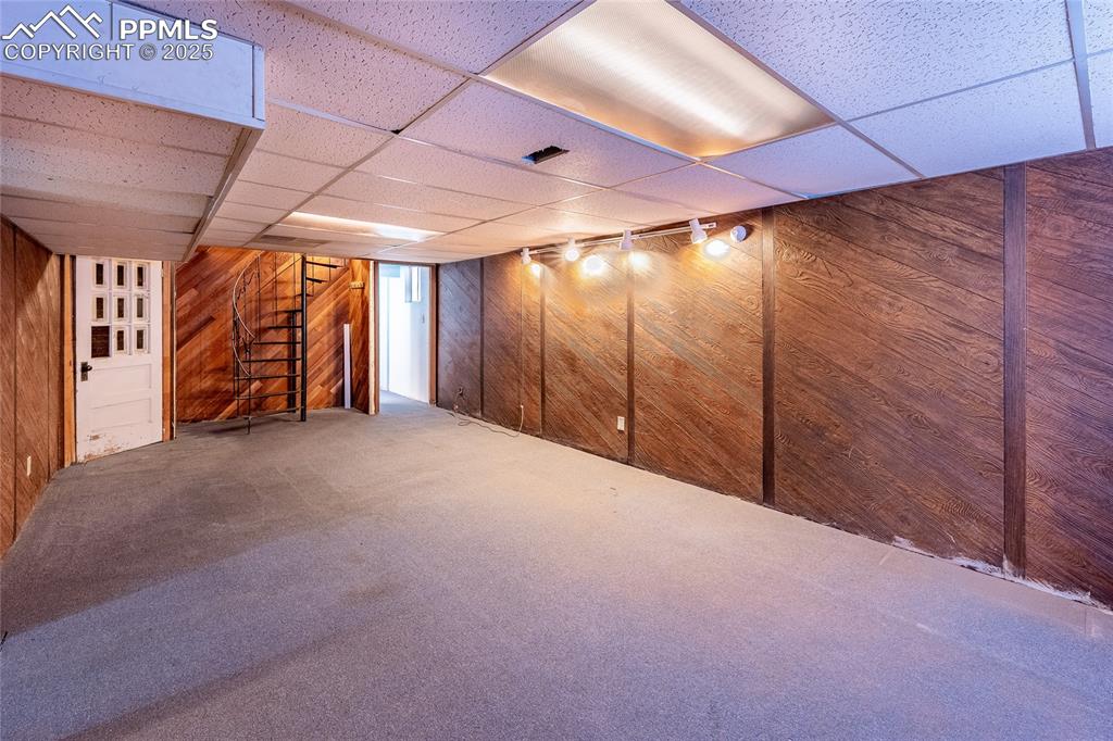 Image 12 of 30: Finished below grade area featuring a paneled ceiling, stairway, wooden wal