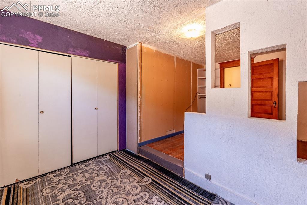 Image 16 of 30: Unfurnished bedroom featuring a textured ceiling and a closet
