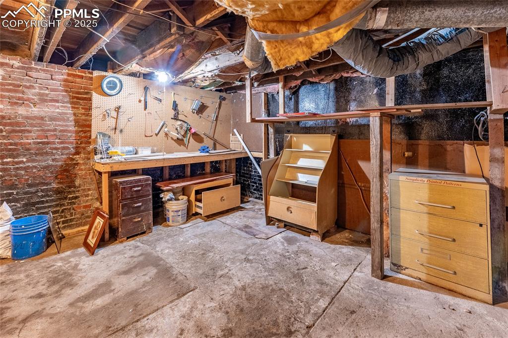 Image 21 of 30: Unfinished basement with a workshop area