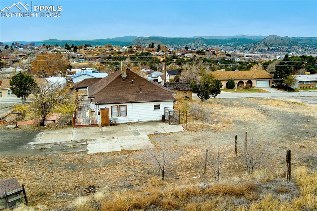 Image 25 of 30: Aerial perspective of suburban area featuring a mountainous background
