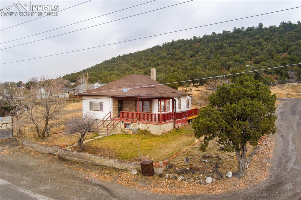Image 3 of 30: View of front of property with a front lawn, a porch, a chimney, and a fore
