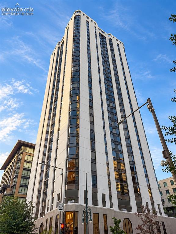 Caption: Modern high-rise with a white facade and dark-tinted windows